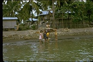 Philippine children at the water's edge near houses, Republic of the Philippines, 1973