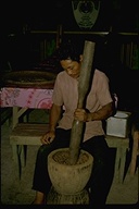 Philippine man grinding seeds with a mortar and pestle, Republic of the Philippines, 1973