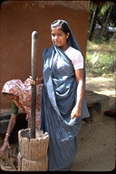 Young girl working (pounding grain?) in Colombo, Sri Lanka