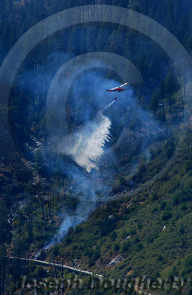 CDF firefighting helicopter emptying suspension bag to fight a wildfire.
