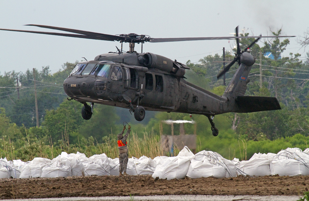 Attaching bags of sand to Blackhawk helicopter..