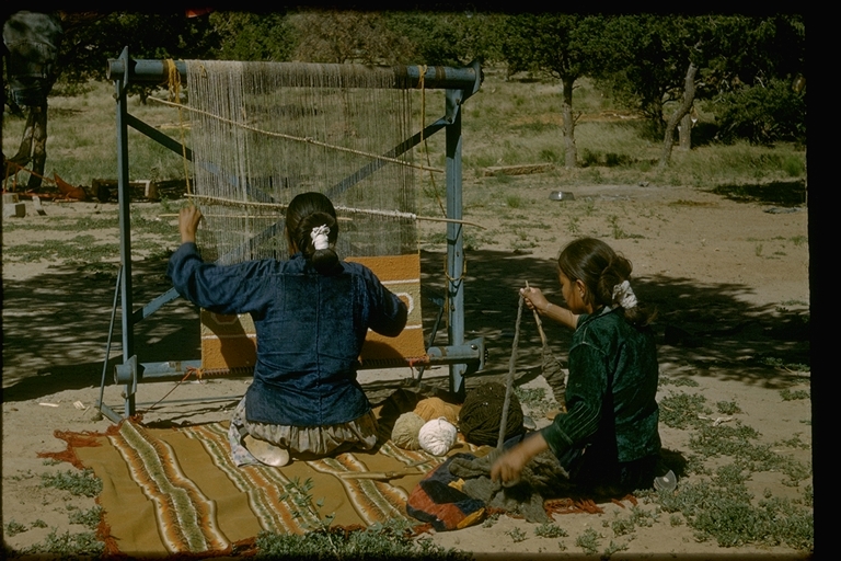 Women weaving rugs on outdoor loom