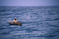 Garifuna fisherman hand-lining from dugout canoe in open waters off the coast of Punta Gorda.