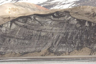 glacier face with volcanic eruption debris