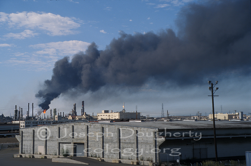 Thick black smoke emanates from the Richmond Refinery.